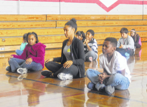 Nicole meditating with students at a school